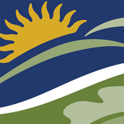 Stylized sun rising over waves and hills in an abstract landscape design.